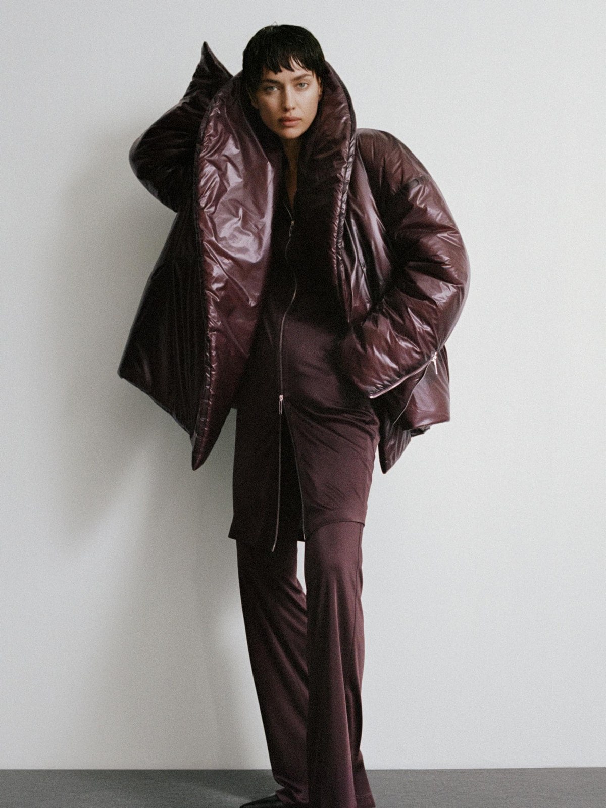 Irina Shayk wearing a deep plum puffer jacket with coordinating trousers