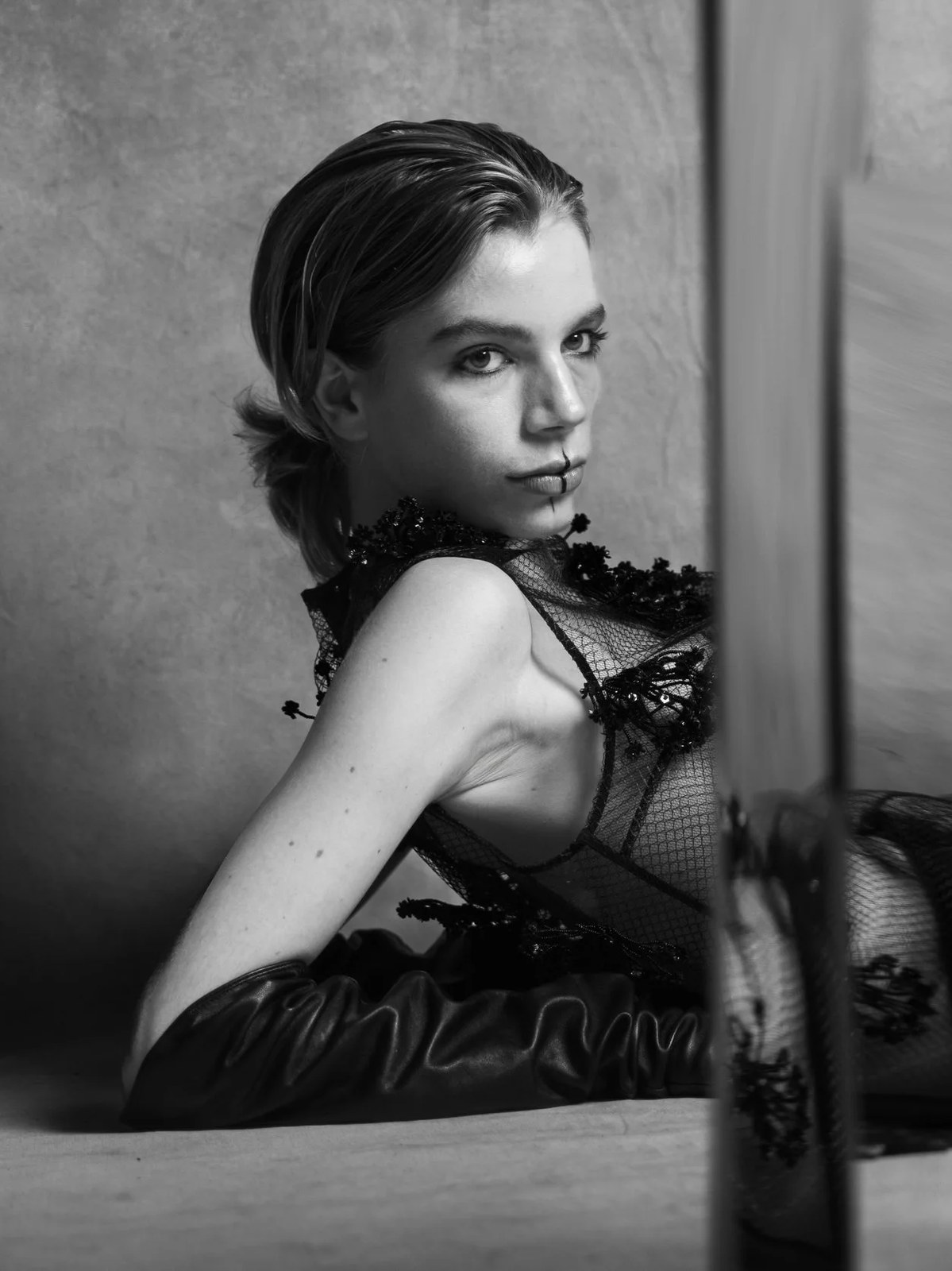 Vera Kuntz reclining in a lace top and gloves, framed by a studio mirror