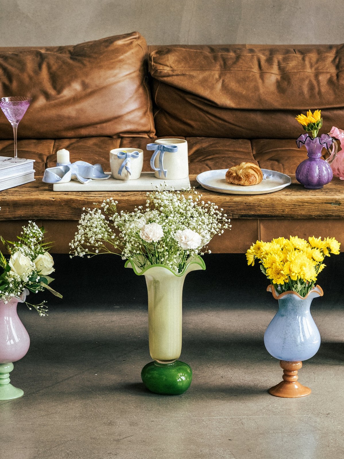 Colorful vases and cocktail glasses styled on a rustic console