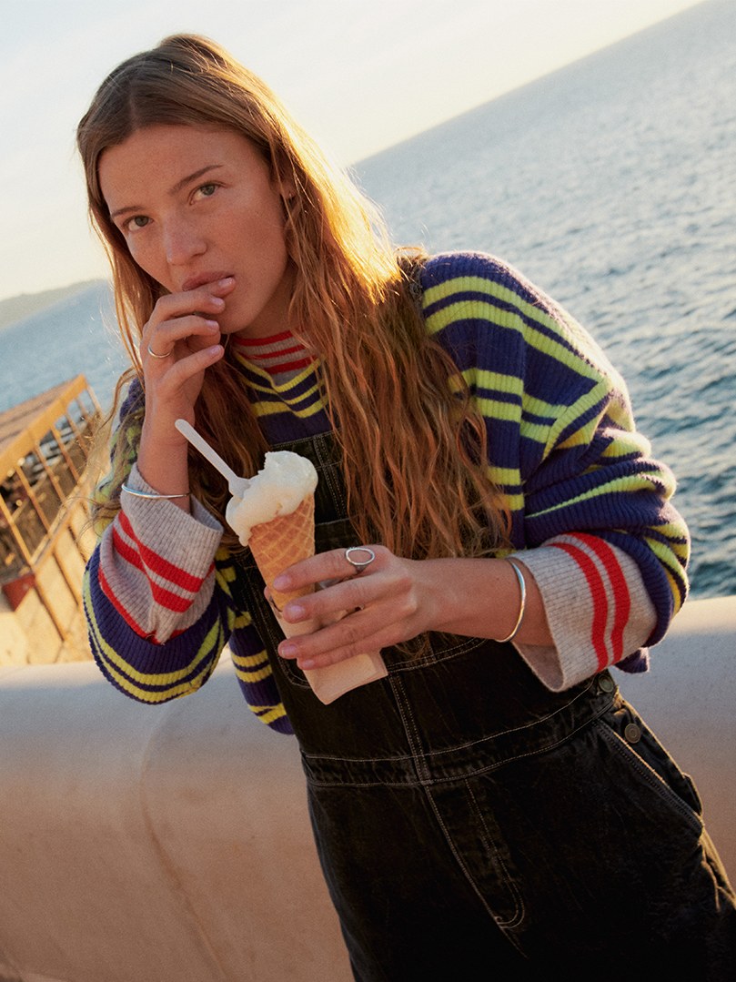 Woman in a multicolor knit by the Mediterranean