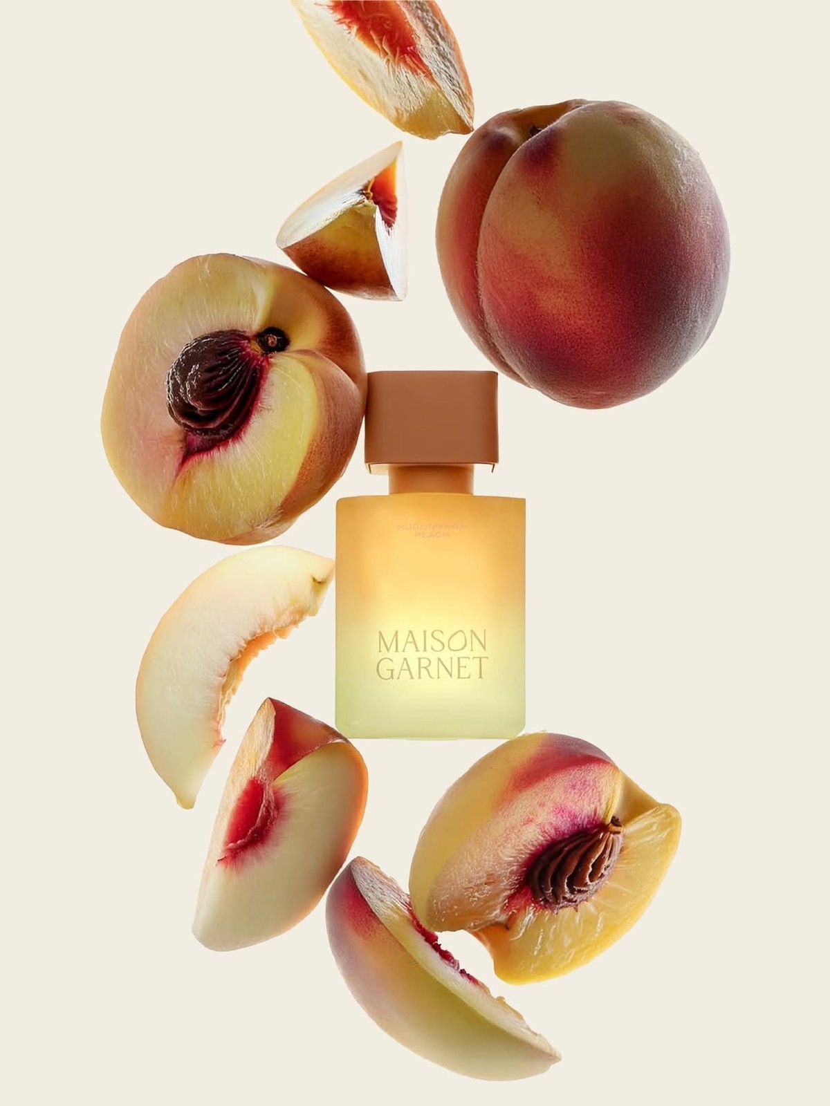 Maison Garnet peach perfume bottle surrounded by fresh peach halves and slices