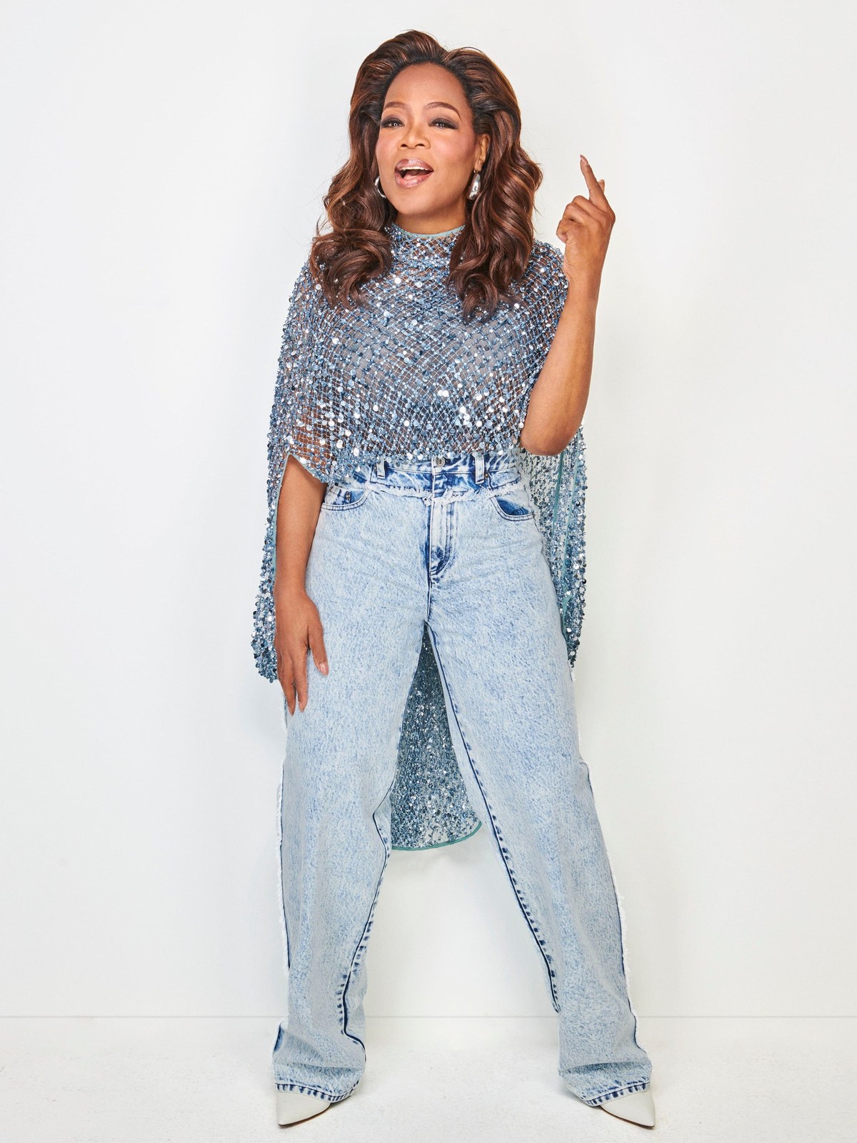 Oprah Winfrey wearing a blue embellished LaPointe top with pale jeans