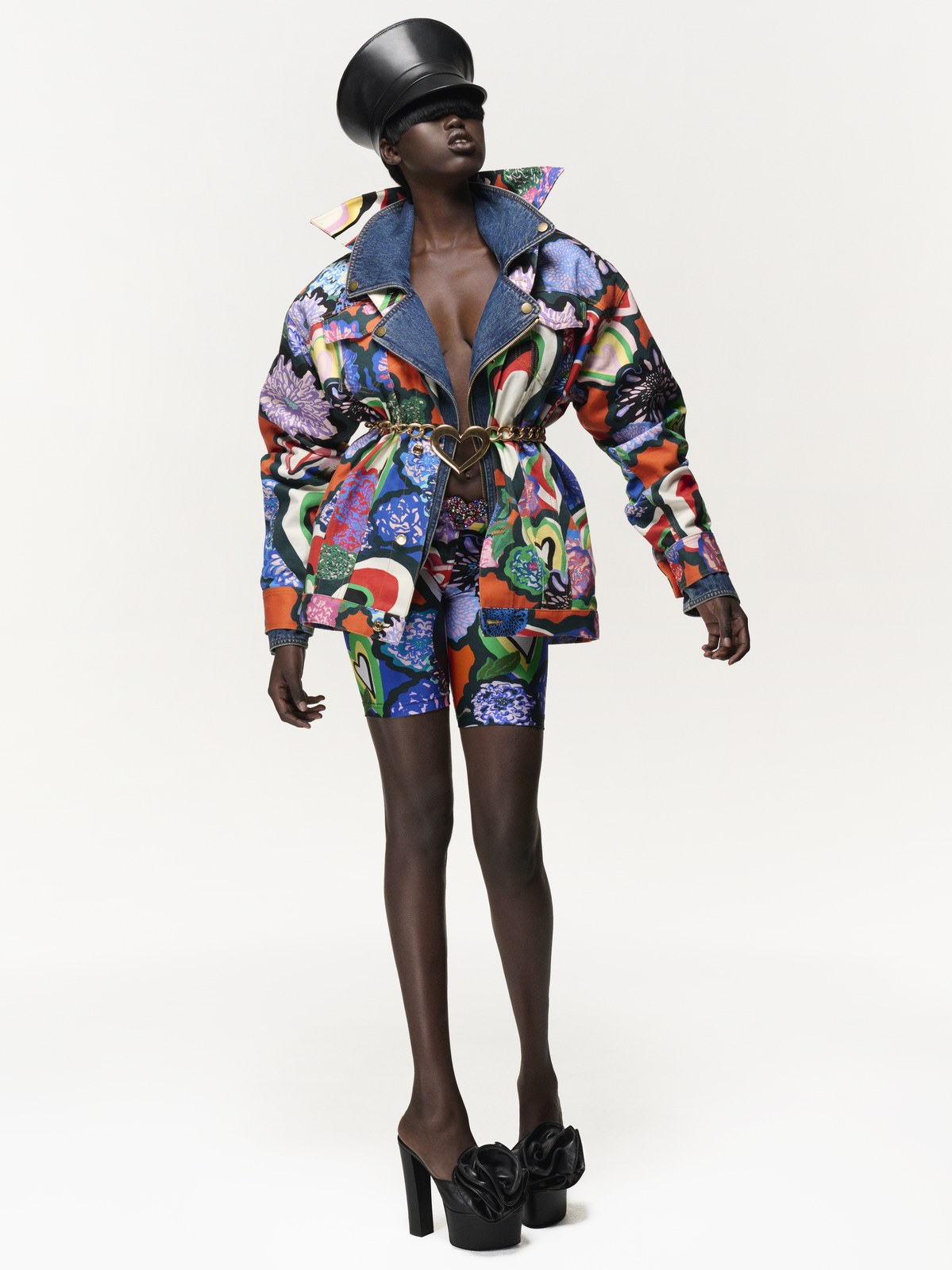 Model in a colorful printed AREA jacket and shorts with platform shoes