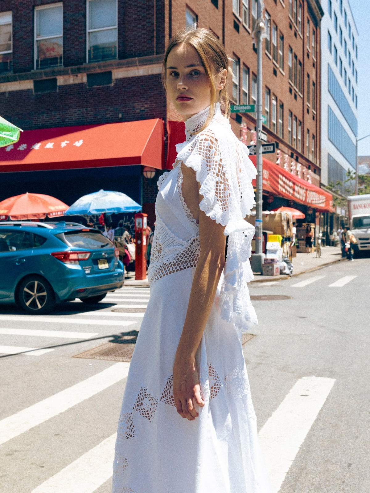 Model in a white lace look on a busy city street