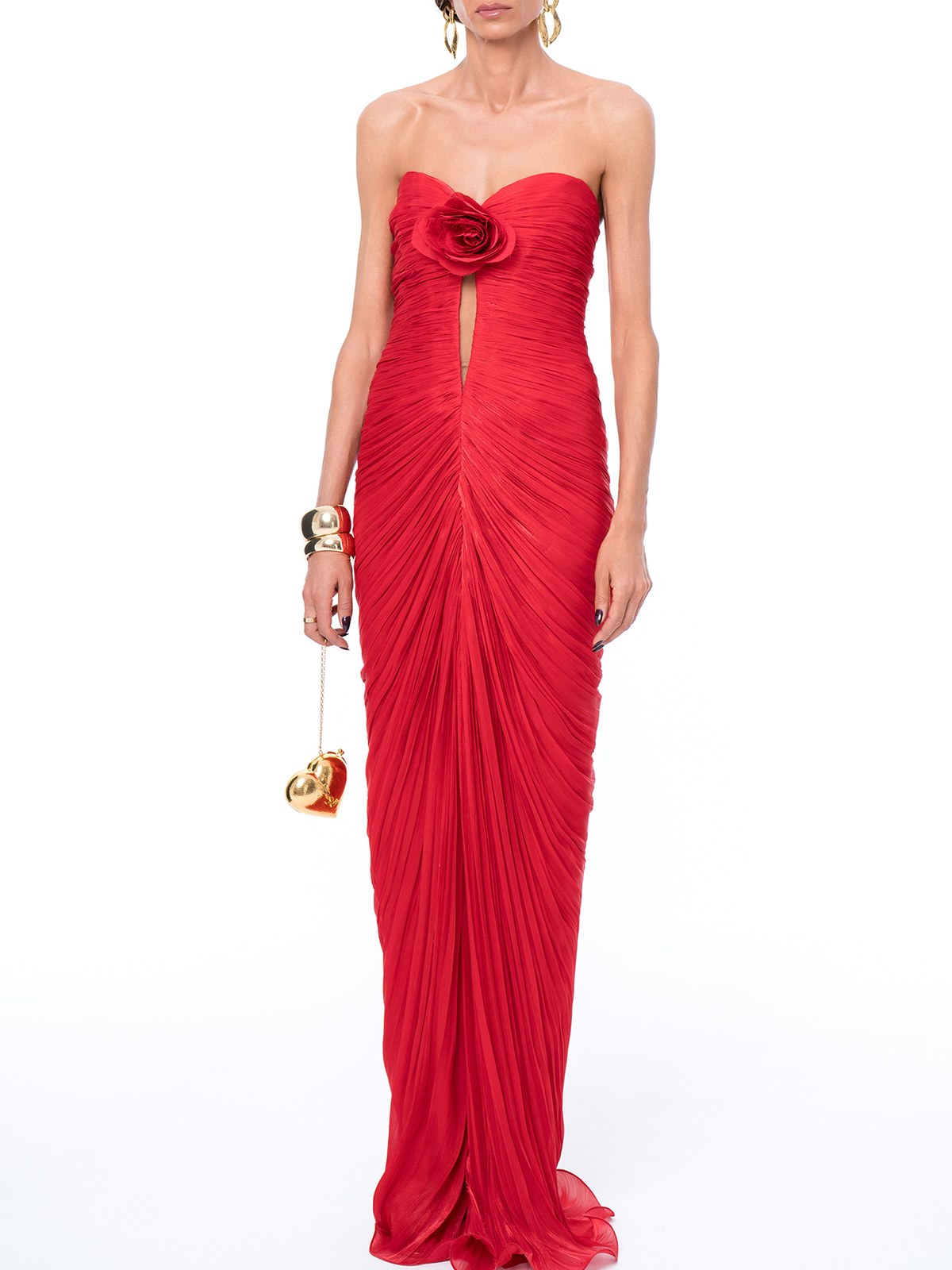 Model in a red ruched strapless chiffon gown with rose detail and a gold heart clutch