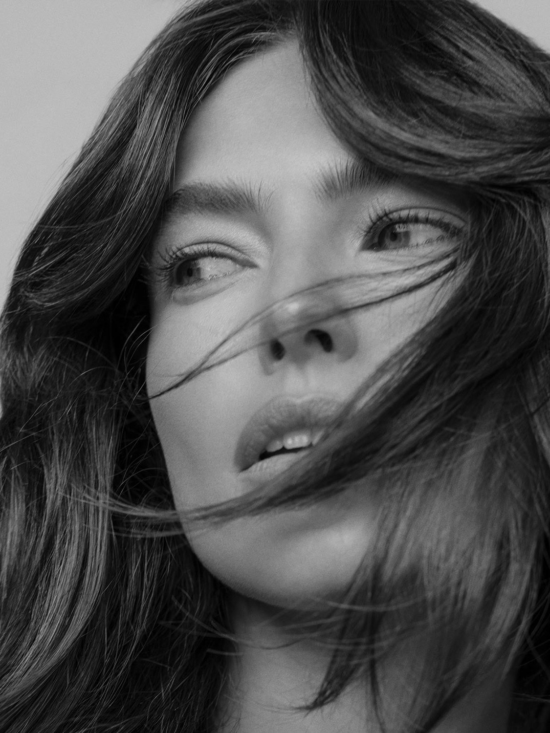Brunette model with wind-swept hair in a monochrome beauty portrait