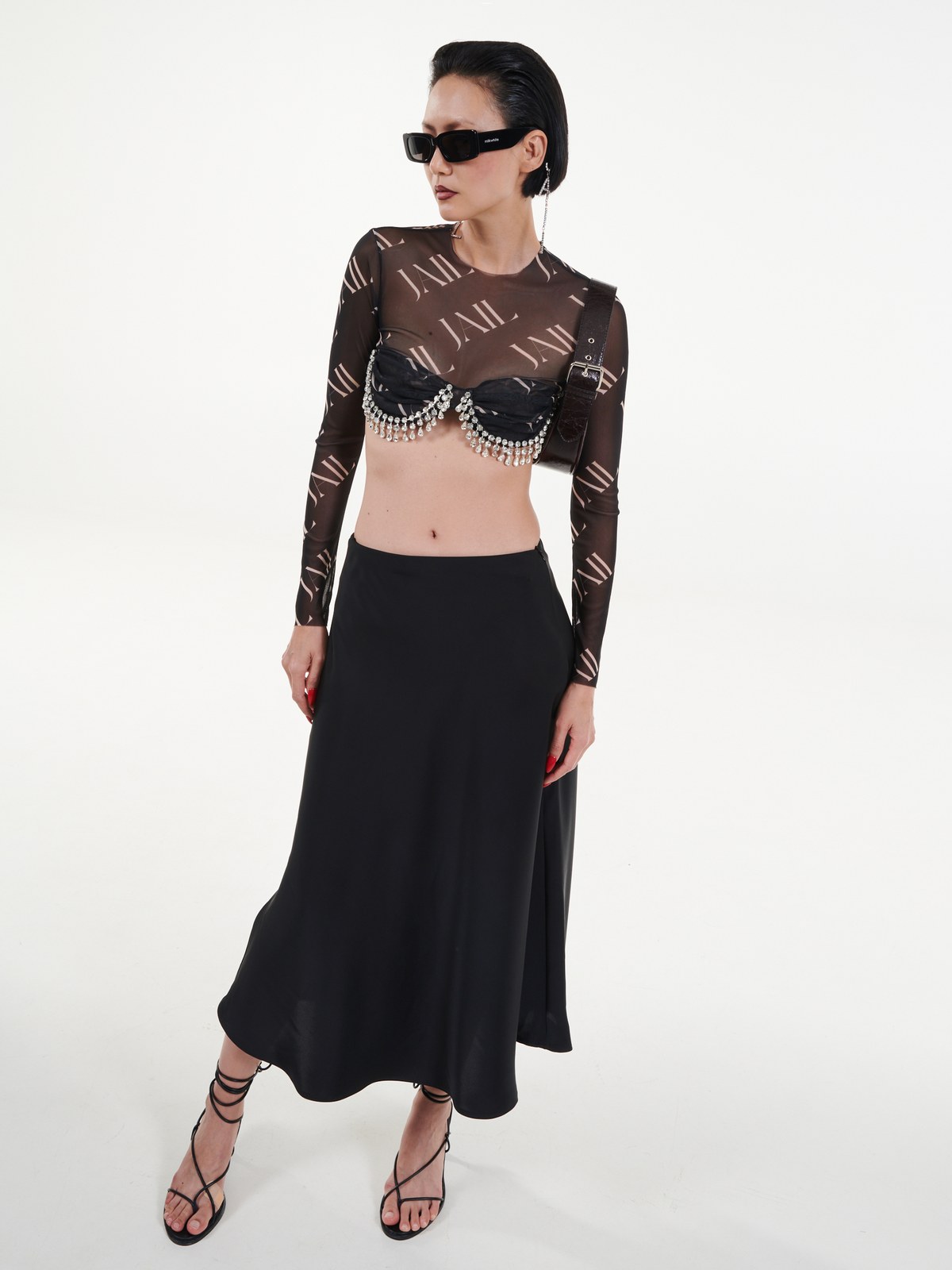 Model in a sheer black top and long skirt