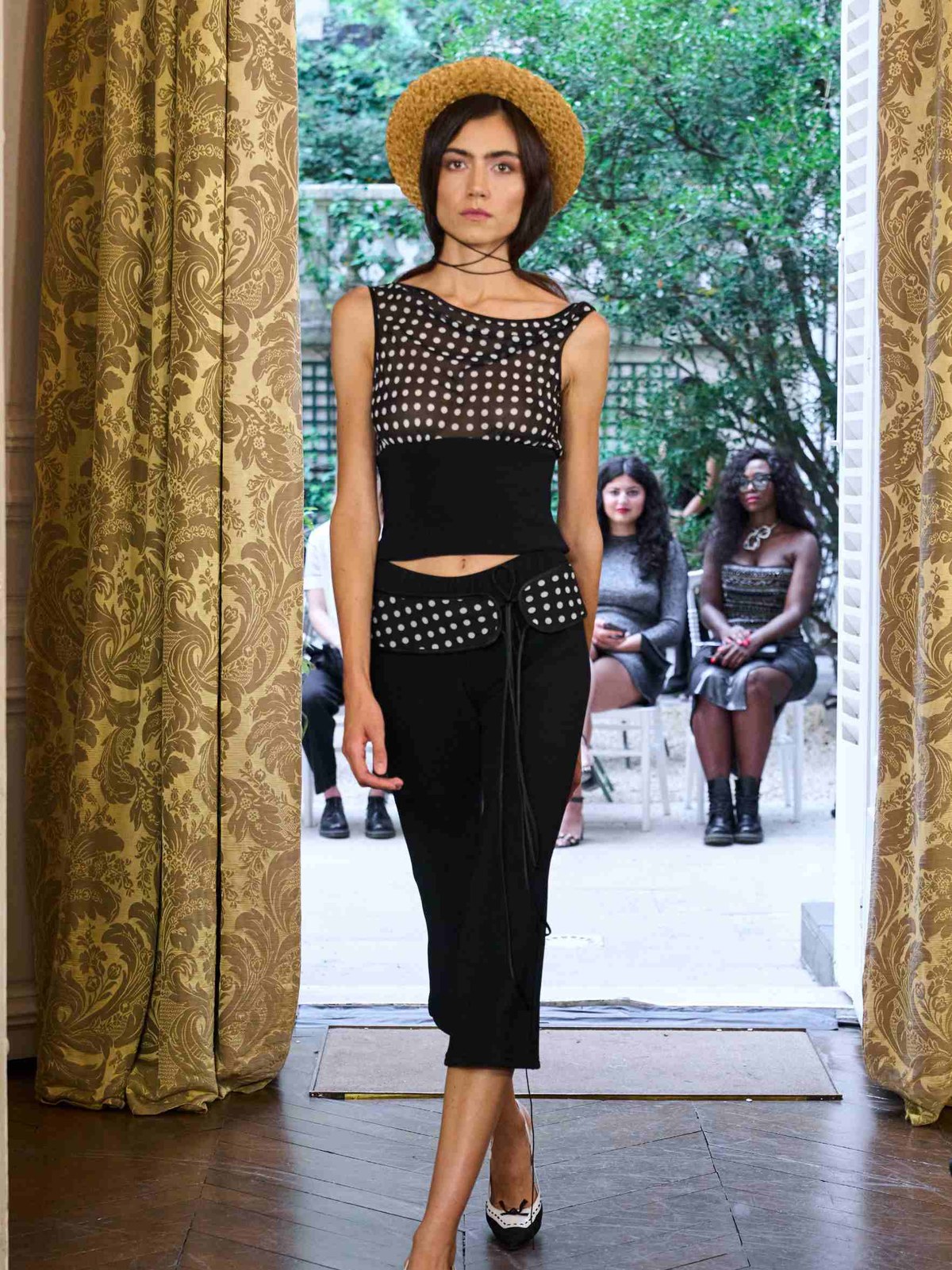 Runway model in a black Fait Par Foutch crop top and trousers