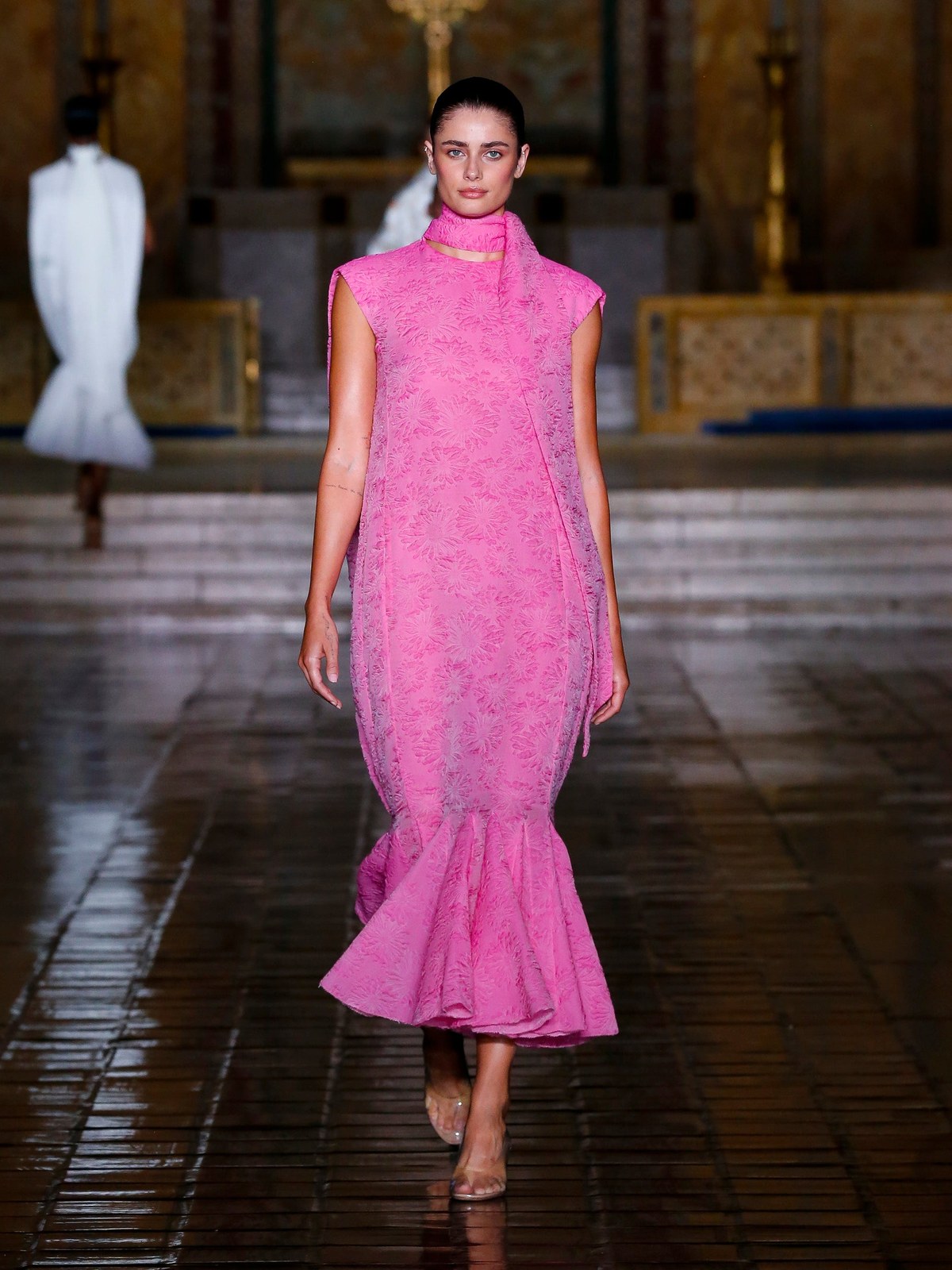 A model wears a bright pink dress on the Spring Summer 2026 runway.