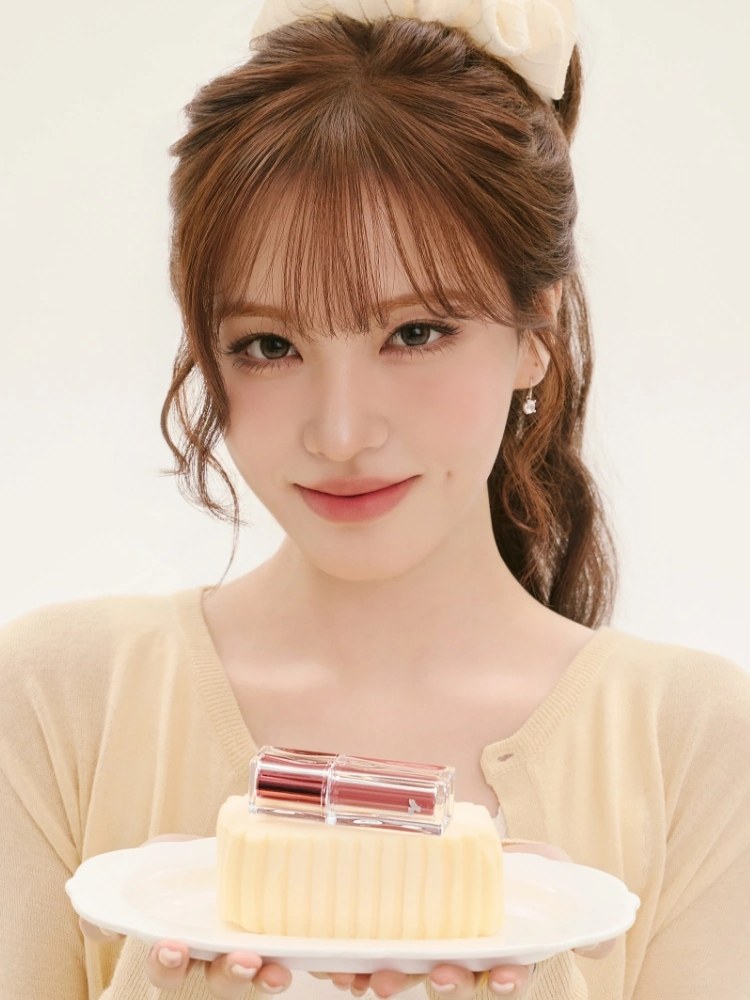 Liz holding a TONYMOLY lip tint on a cream studio set
