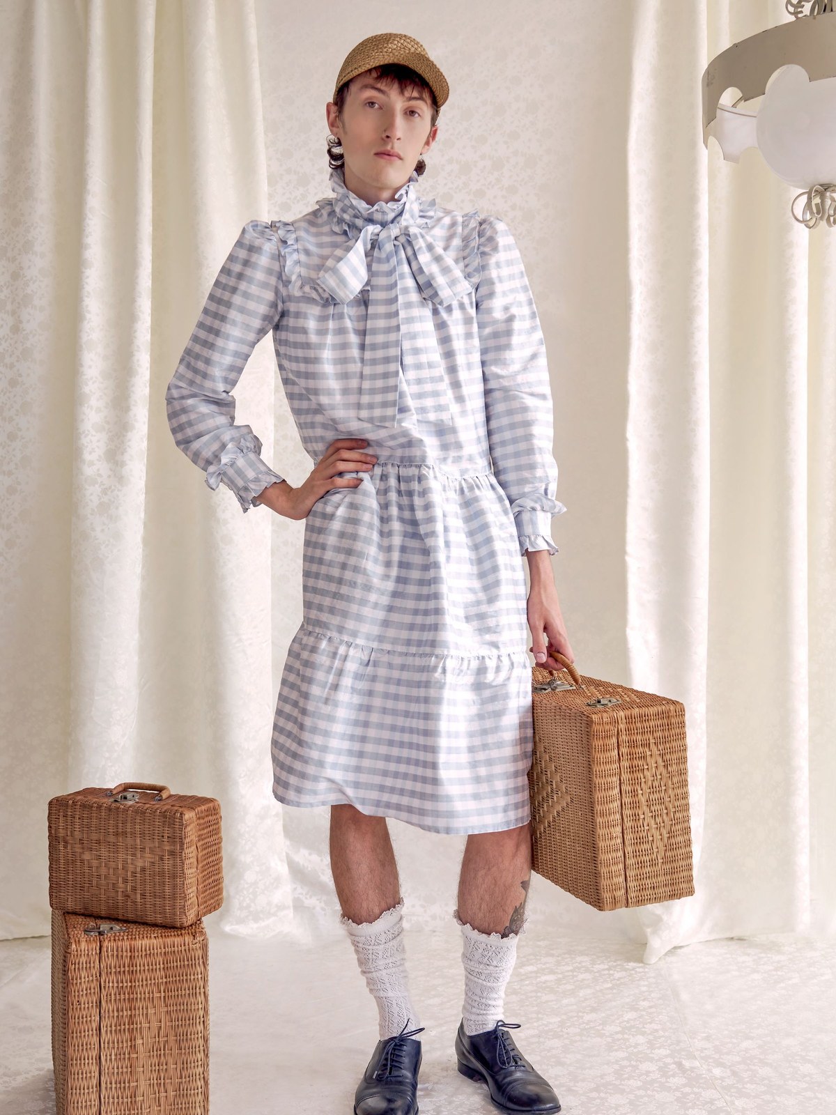 Model in a gingham dress with woven suitcases