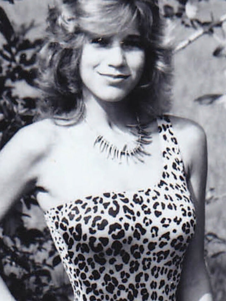 Archival black-and-white photo of a model in a leopard-print swimsuit
