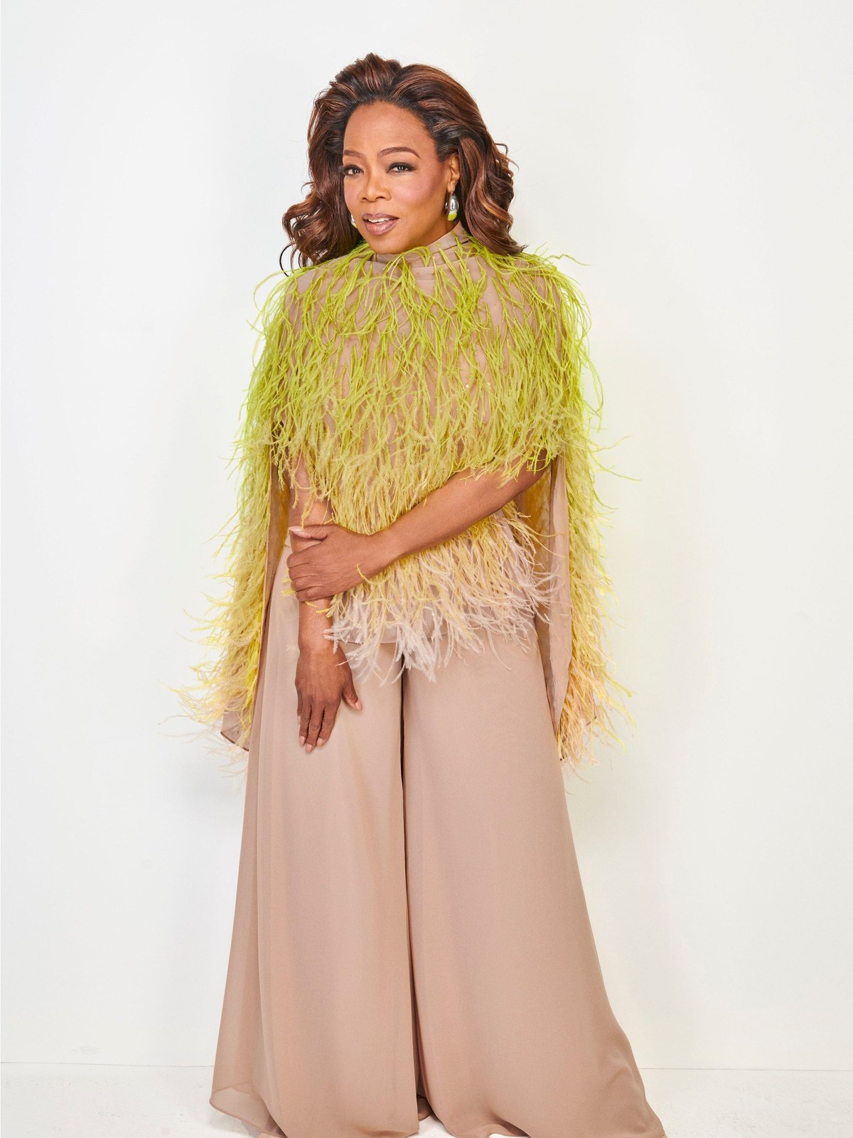 Oprah Winfrey in a lime feathered LaPointe top and pale trousers