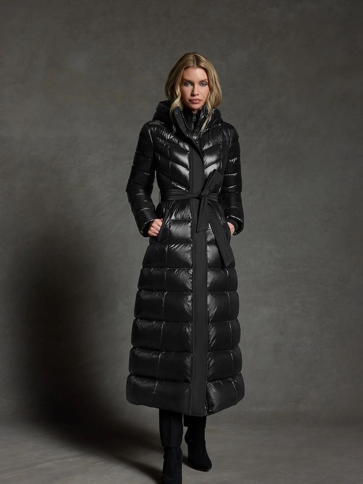 Model in a long black quilted puffer coat