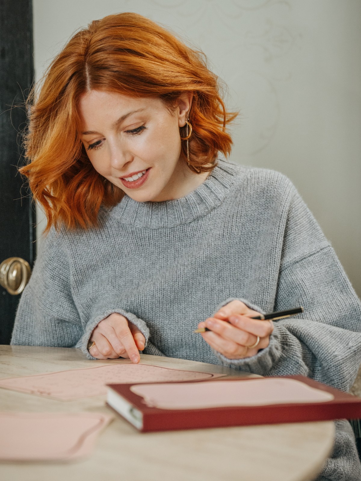 Stacey Dooley writing at a table with Papier stationery