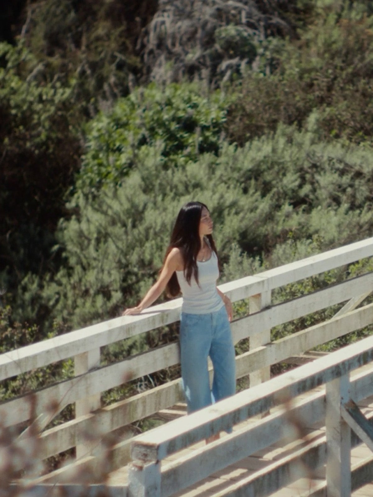 Jessica Mau in AG jeans on a coastal bridge