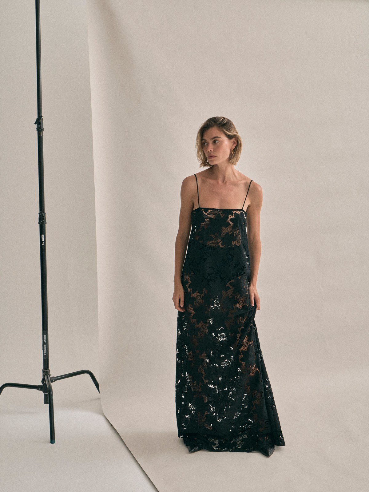 Model in a black lace gown on a studio set