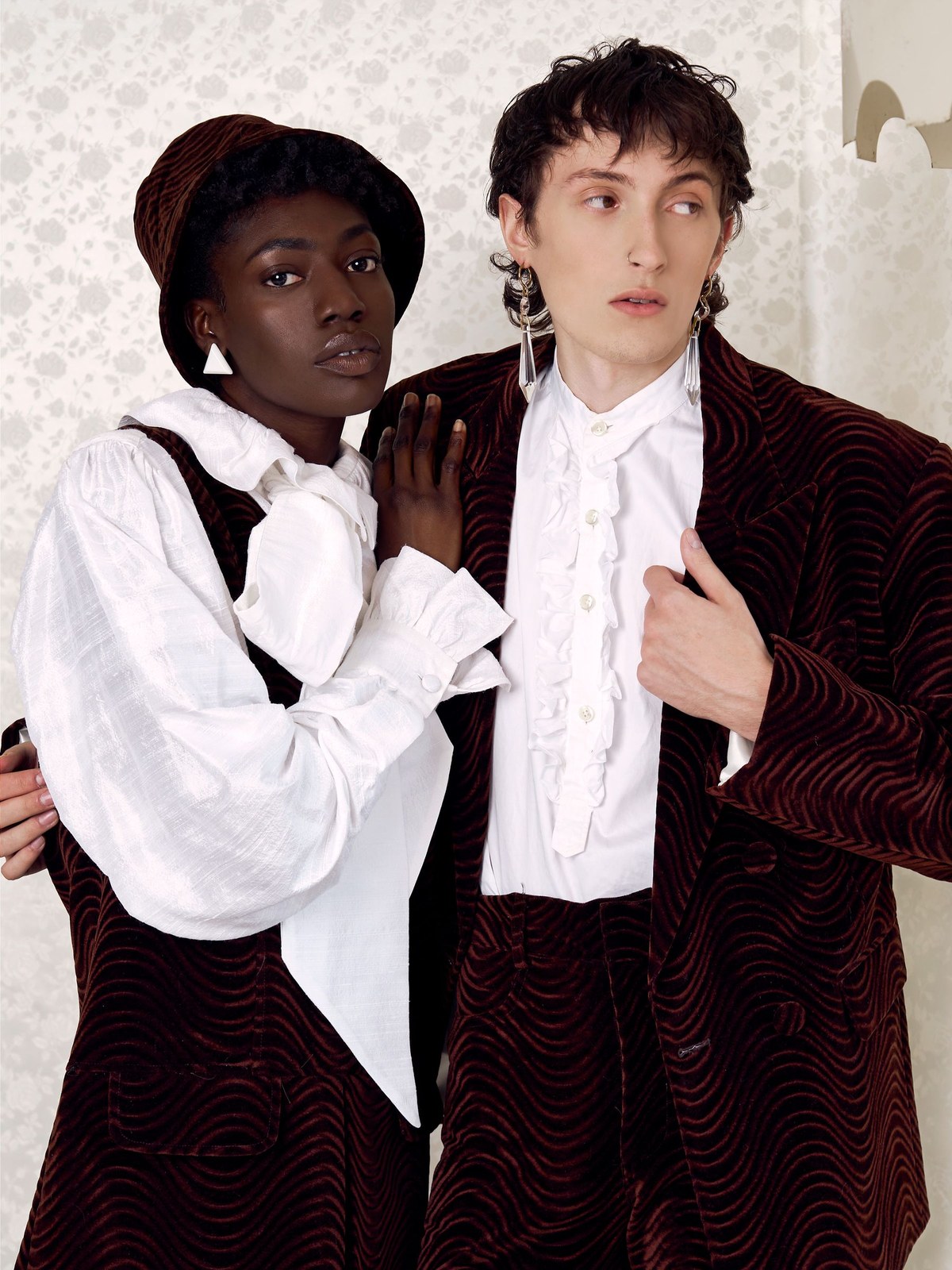 Two models in ruffled white and brown velvet looks