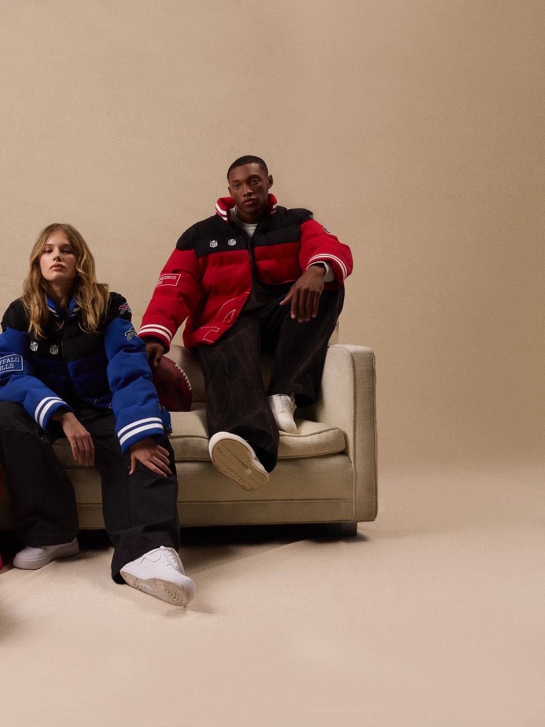 Models wearing football team puffers and sportswear in a neutral studio