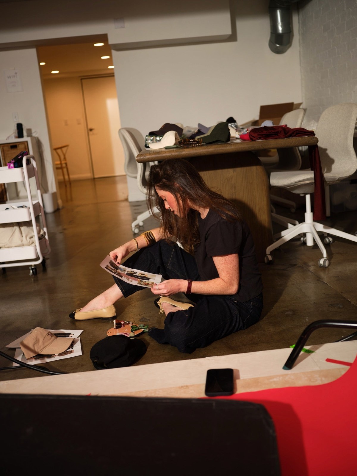 Woman reviewing design materials on the floor of a studio