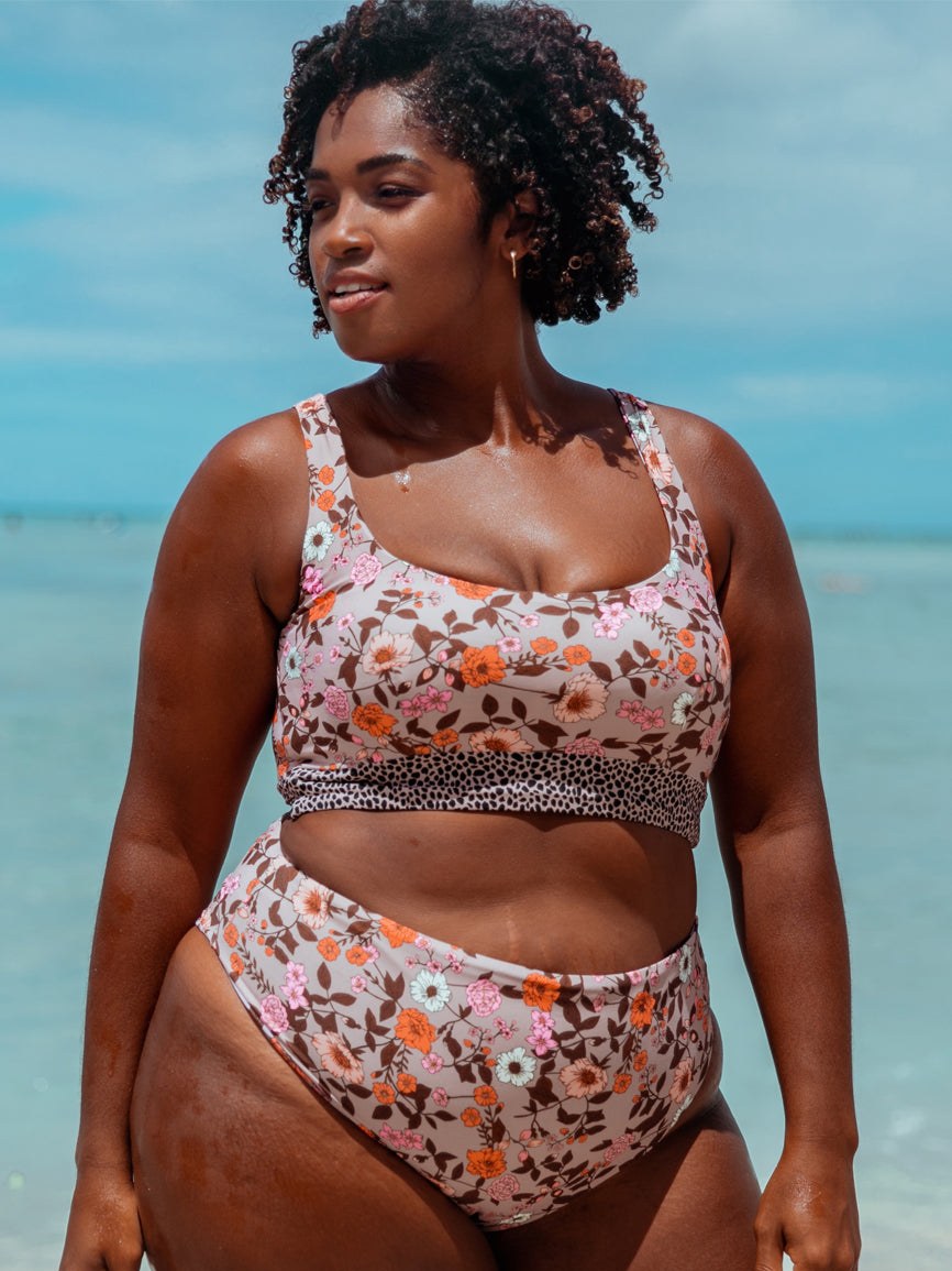 A model in a floral swim set standing against the sea