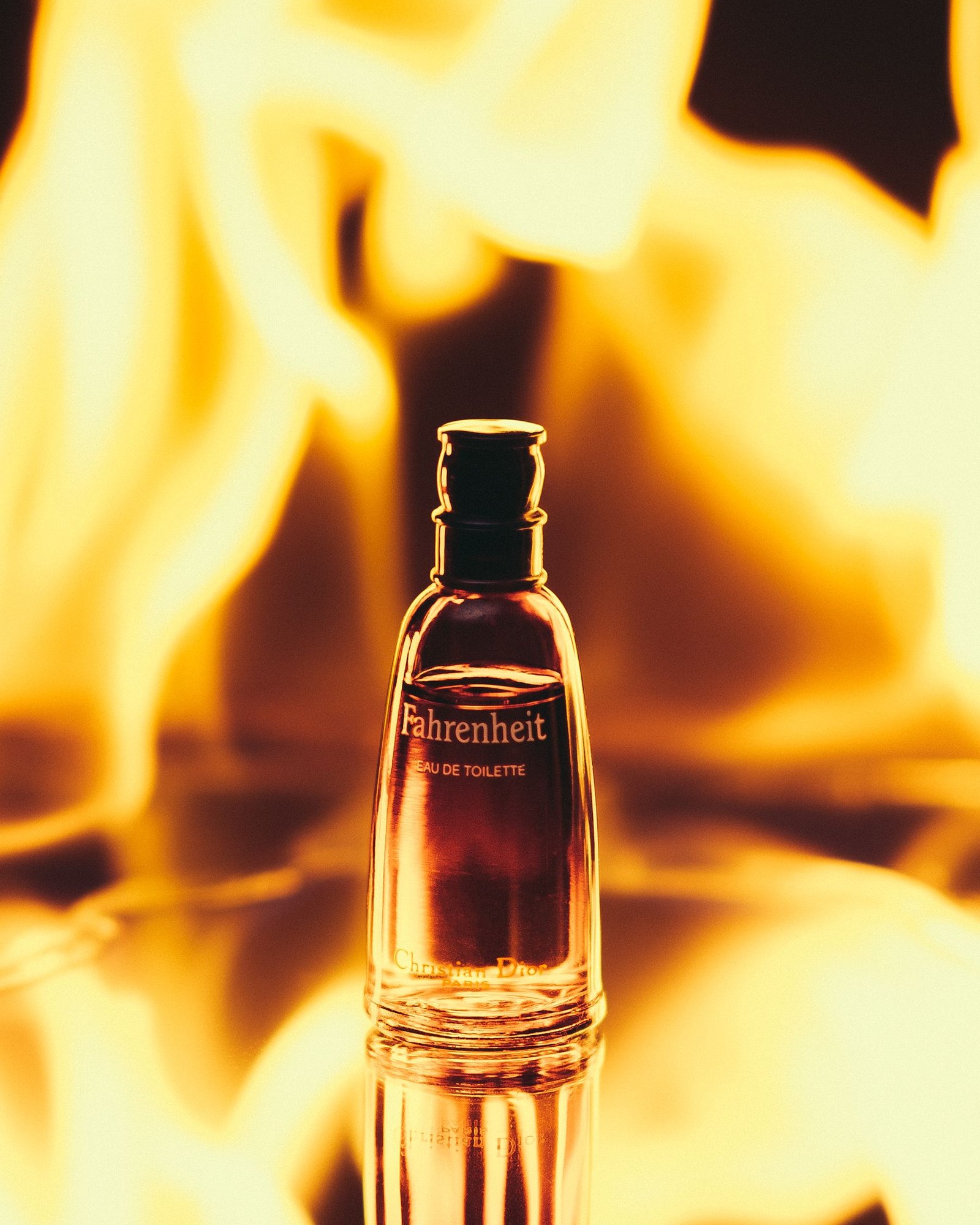 Small Fahrenheit Eau de Toilette bottle standing in front of bright blurred flames