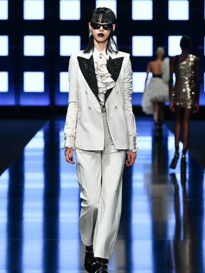 Runway model in a light tailored suit with a dark contrasting lapel