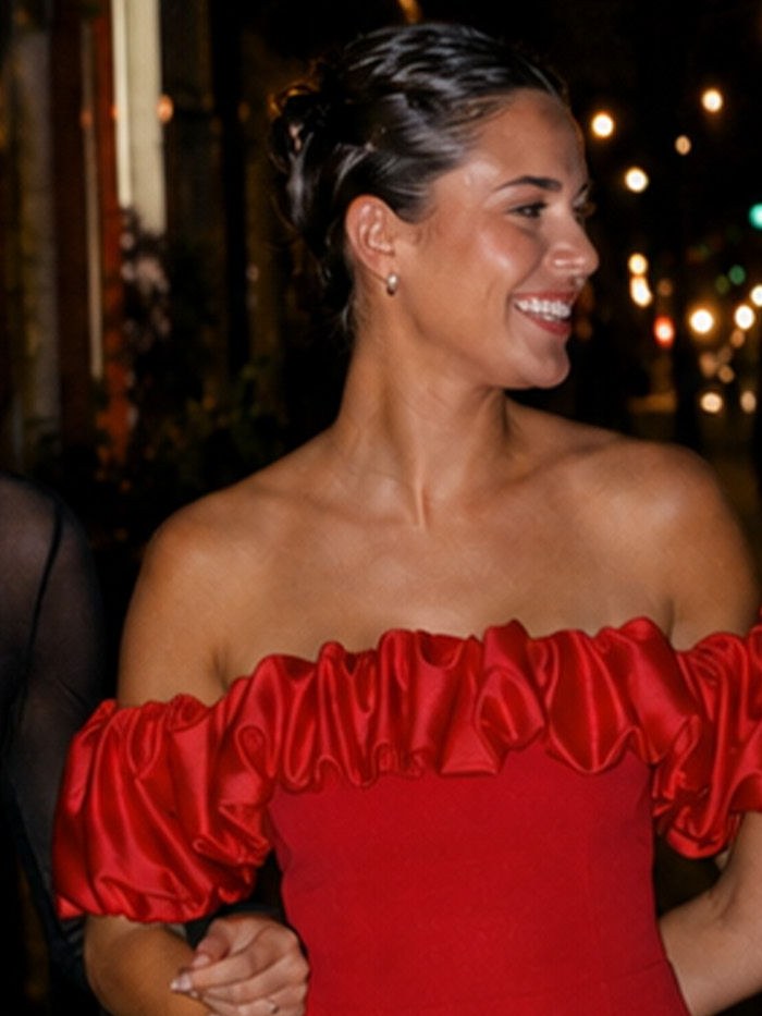 Model in a red LIKELY dress at a nighttime gathering