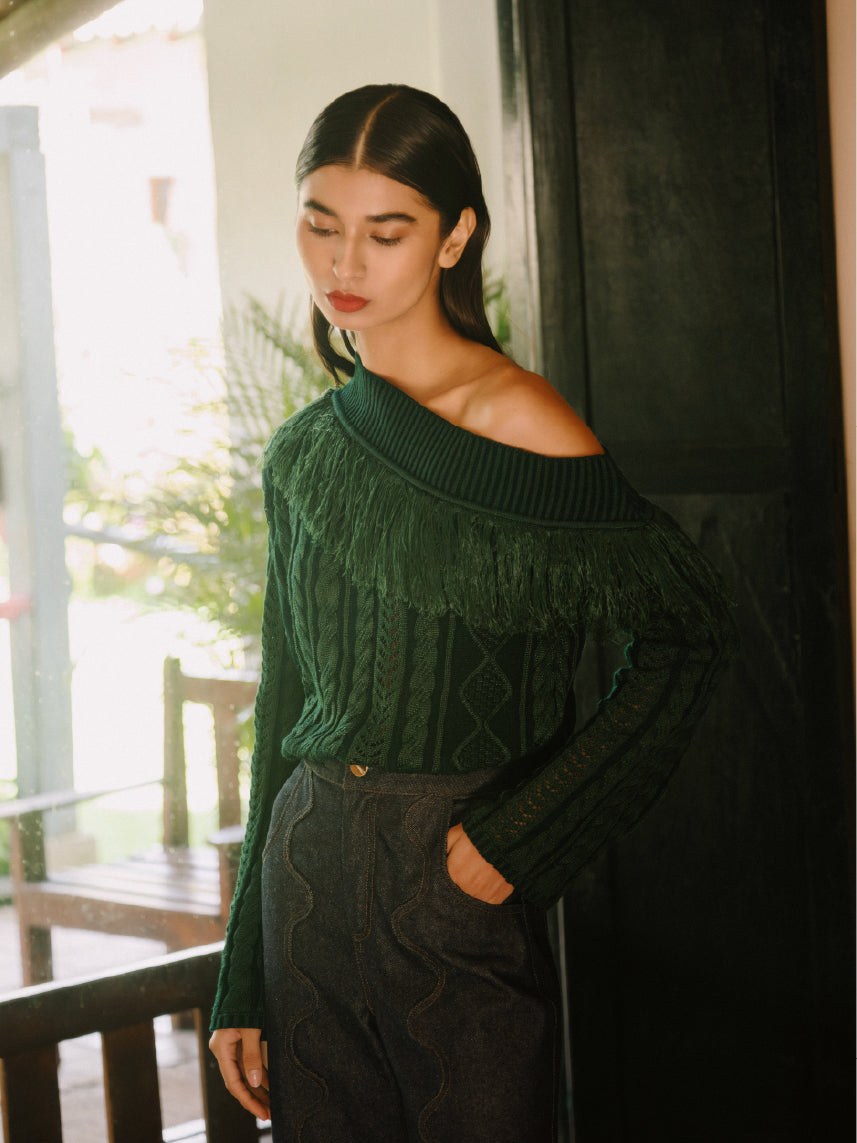 Model in a dark green AZULU sweater by a window