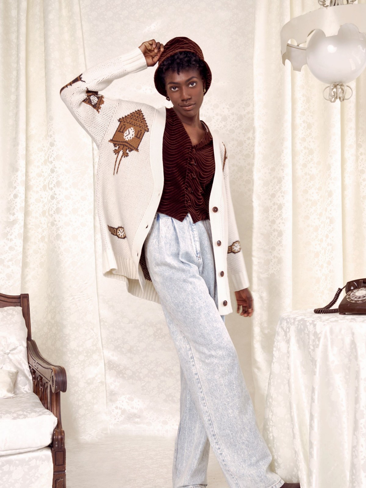 Model in a long white cardigan and brown top with pale trousers