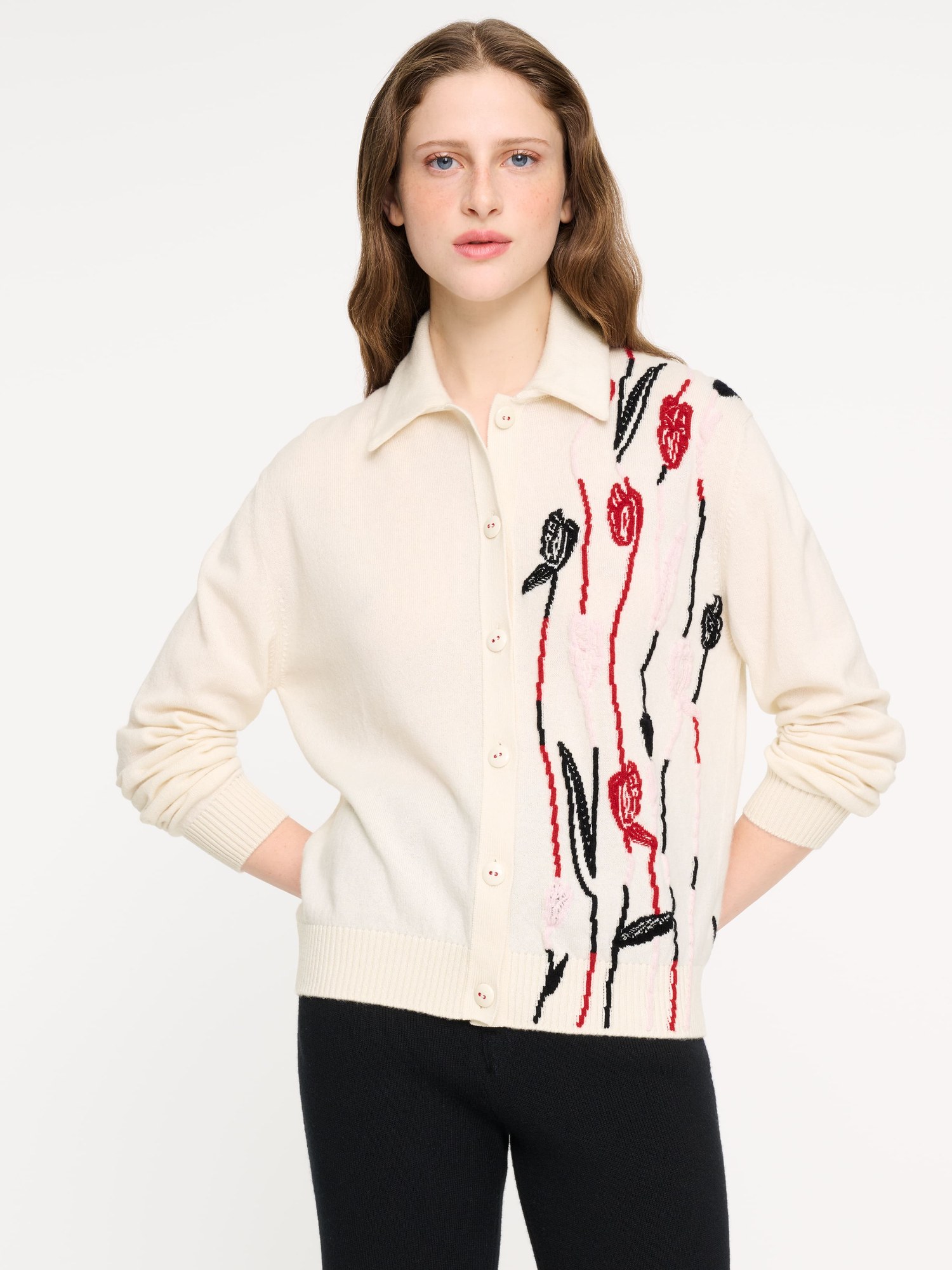 Model in a cream cashmere cardigan with a red and black tulip motif