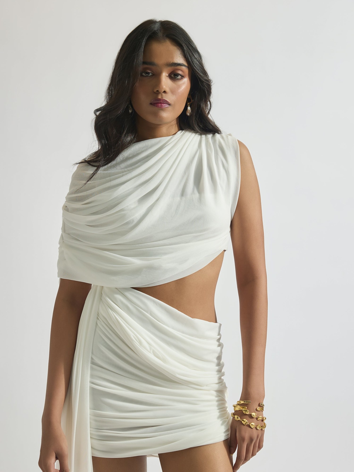 Close crop of a white draped asymmetric top and wrap skirt