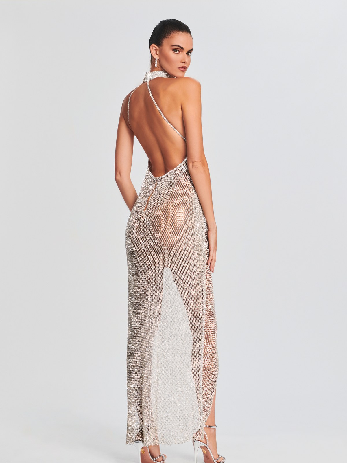 Model in a backless silver evening look from the May Mashiah and Retrofête capsule