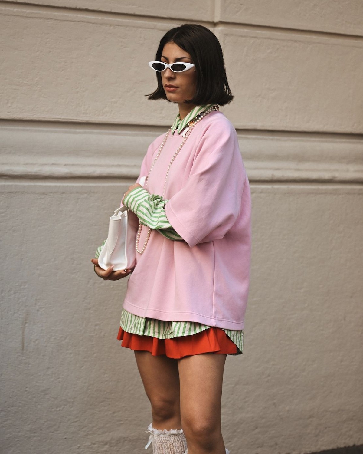 Model in a pink look lounging across a yellow-green sofa