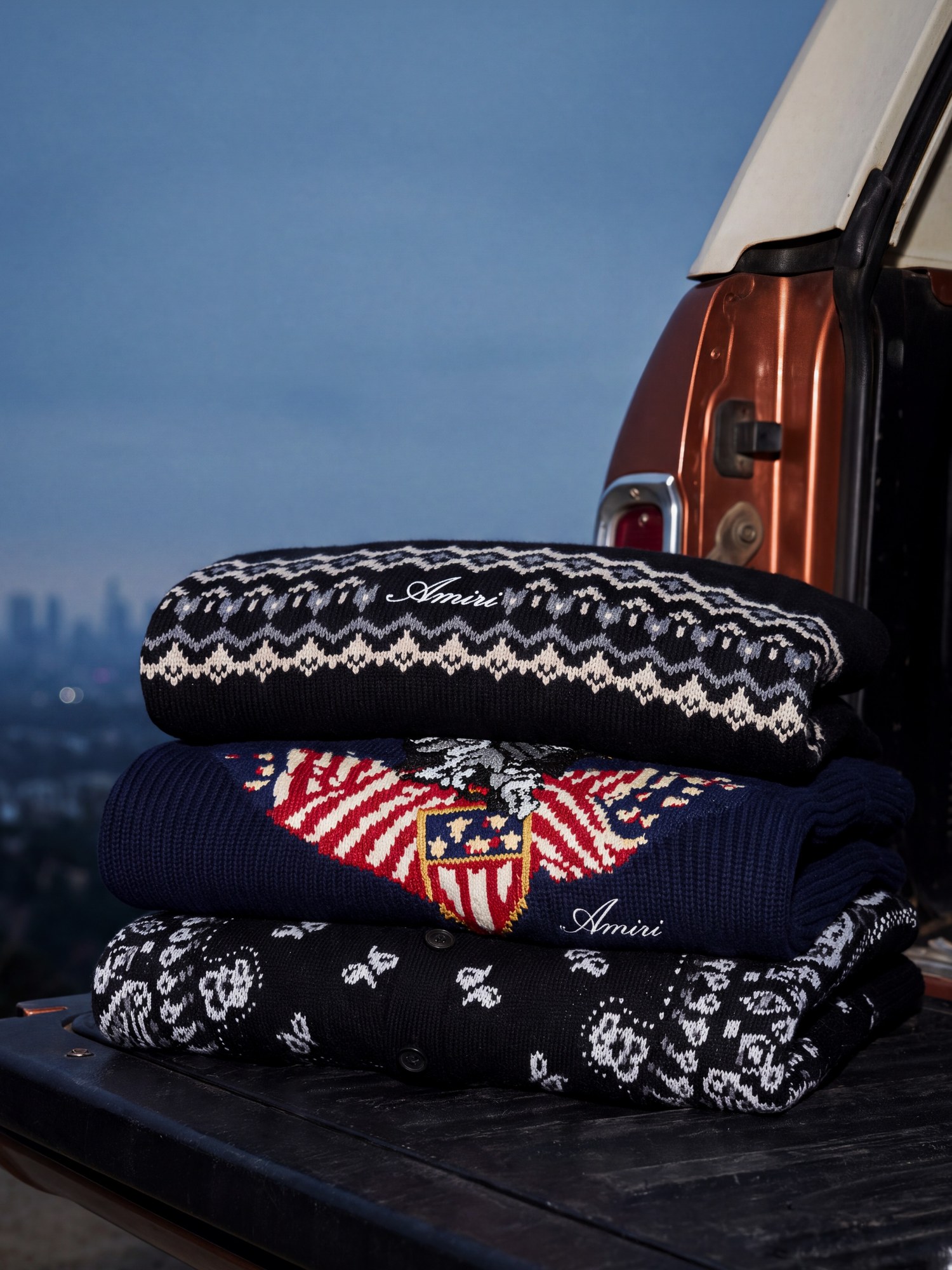 Stack of intarsia knit sweaters on a truck tailgate