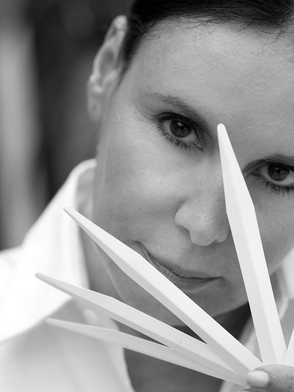 Black and white beauty portrait with white styling pieces across the foreground