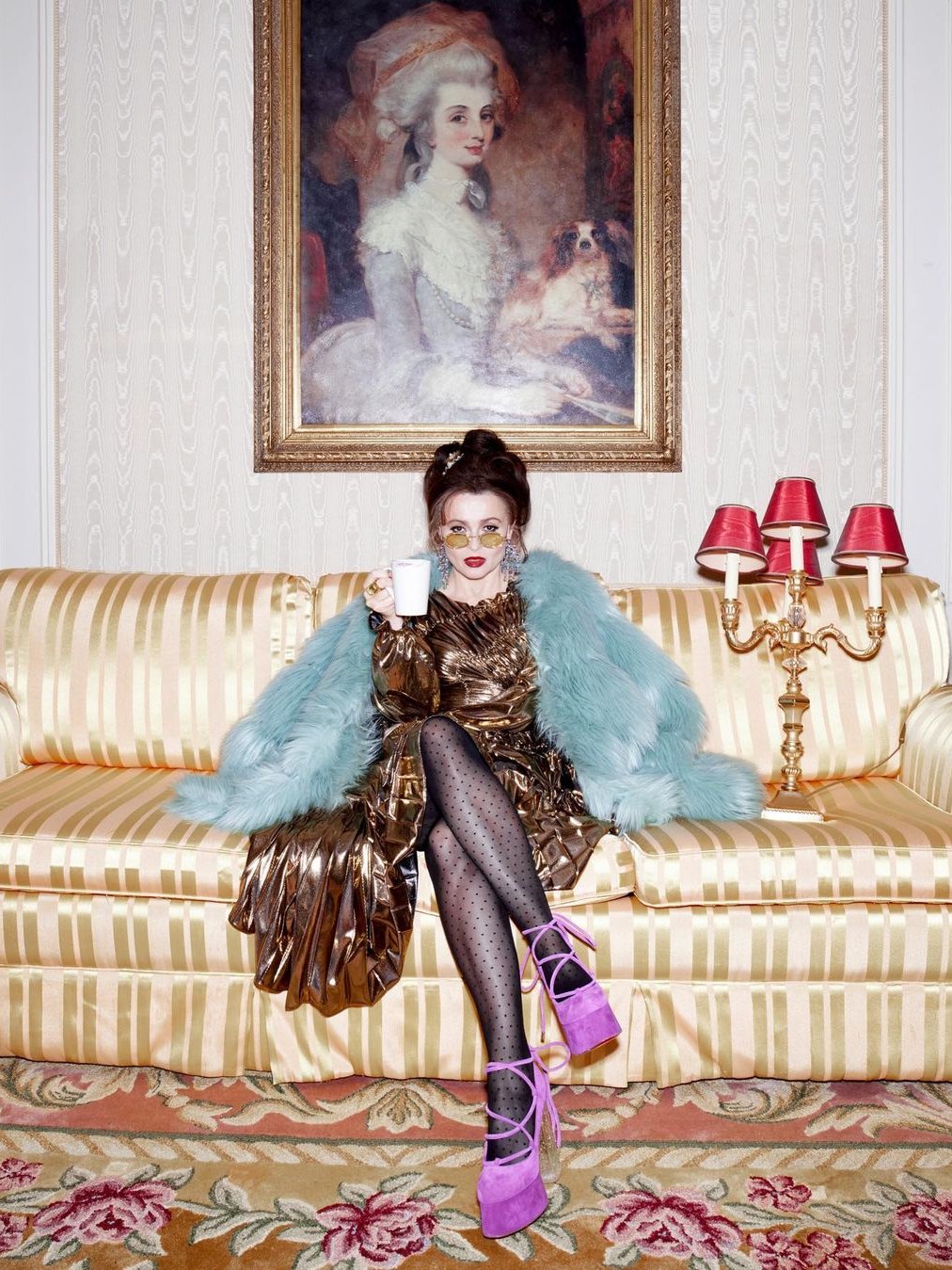 Helena Bonham Carter in a metallic dress seated on a striped sofa