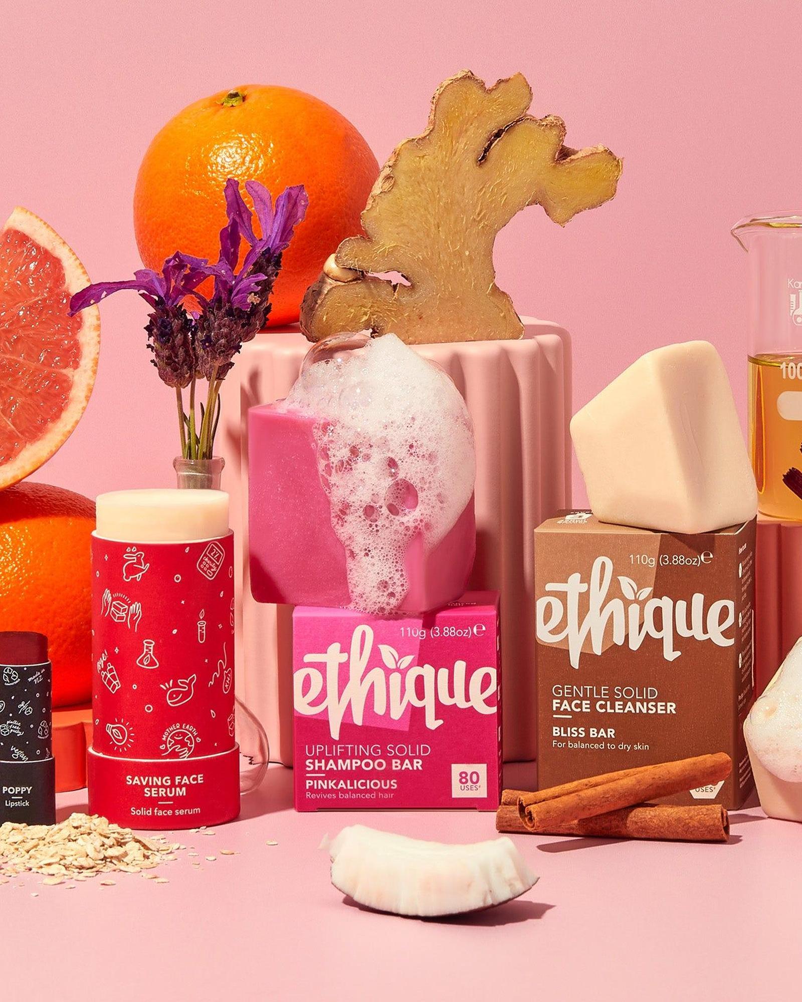 Pink styled set of Ethique Pinkalicious shampoo bar box, Bliss Bar face cleanser and Saving Face Serum with oranges, grapefruit, ginger and lavender