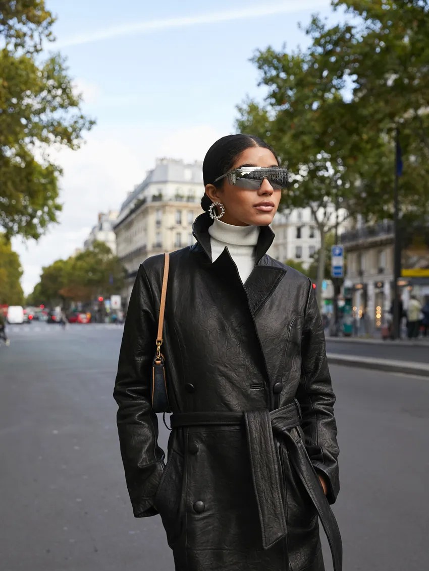 Model in a black belted GRLFRND leather coat on a Paris street