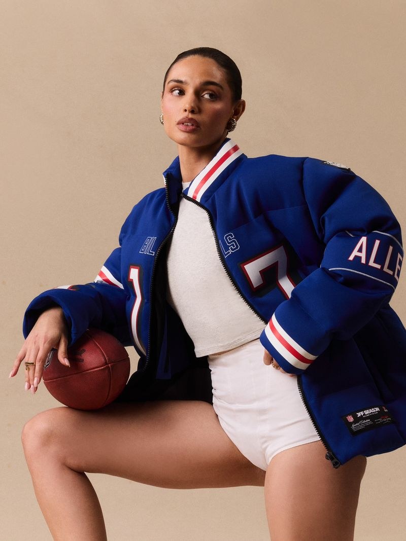 Model in a blue team puffer holding a basketball