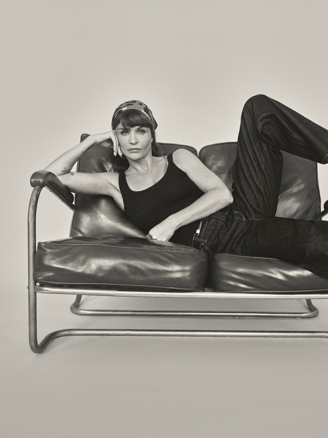 Helena Christensen reclining in ROLLA'S jeans and a dark top