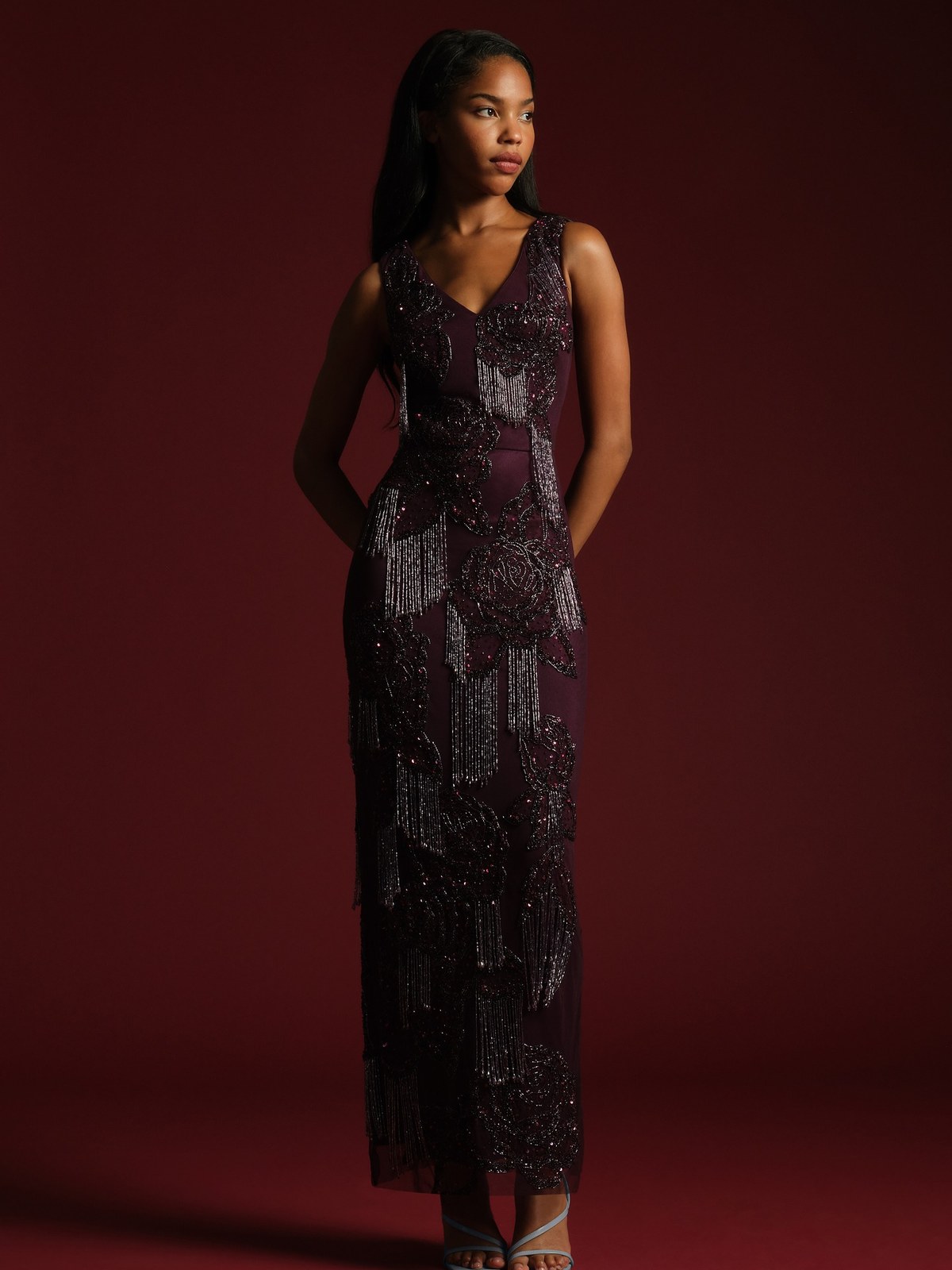 Model in a plum beaded fringe column gown