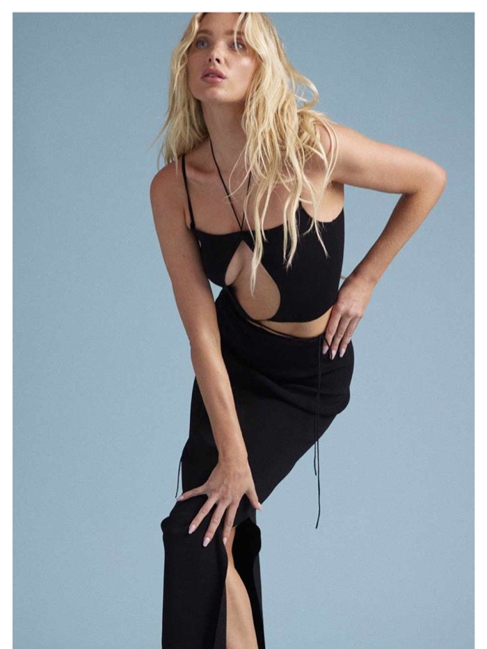 Model wearing a black cutout Aya Muse dress against a blue studio background