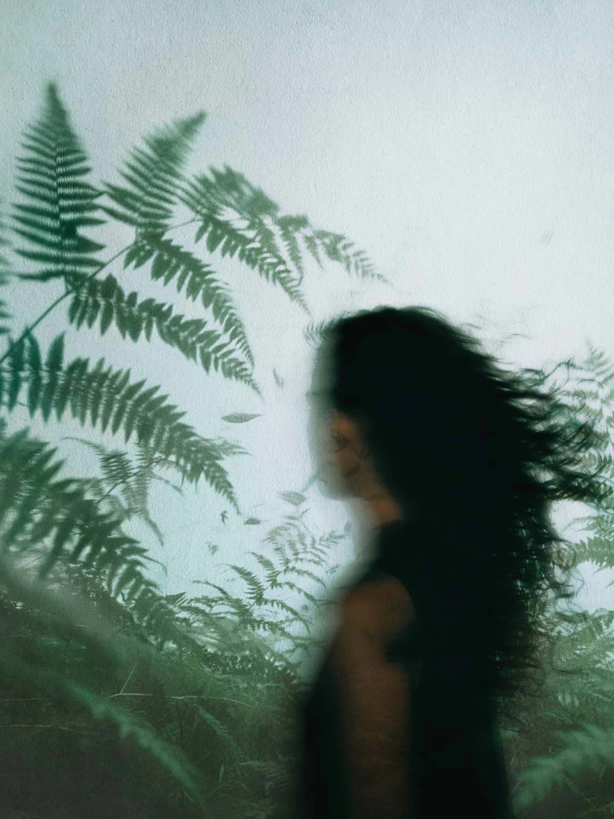 A woman’s profile passes behind fern shadows in an Aesop Fragrant Fables campaign