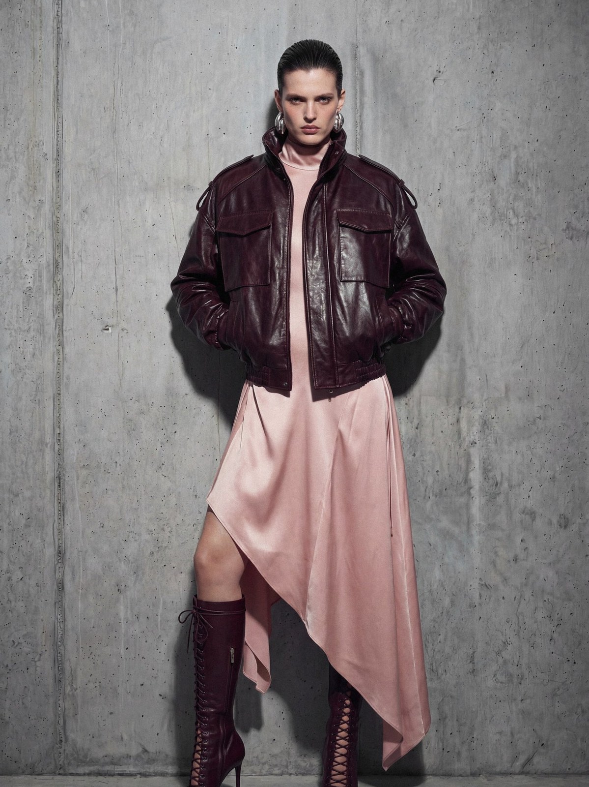 Model in a burgundy jacket over an asymmetric pink skirt