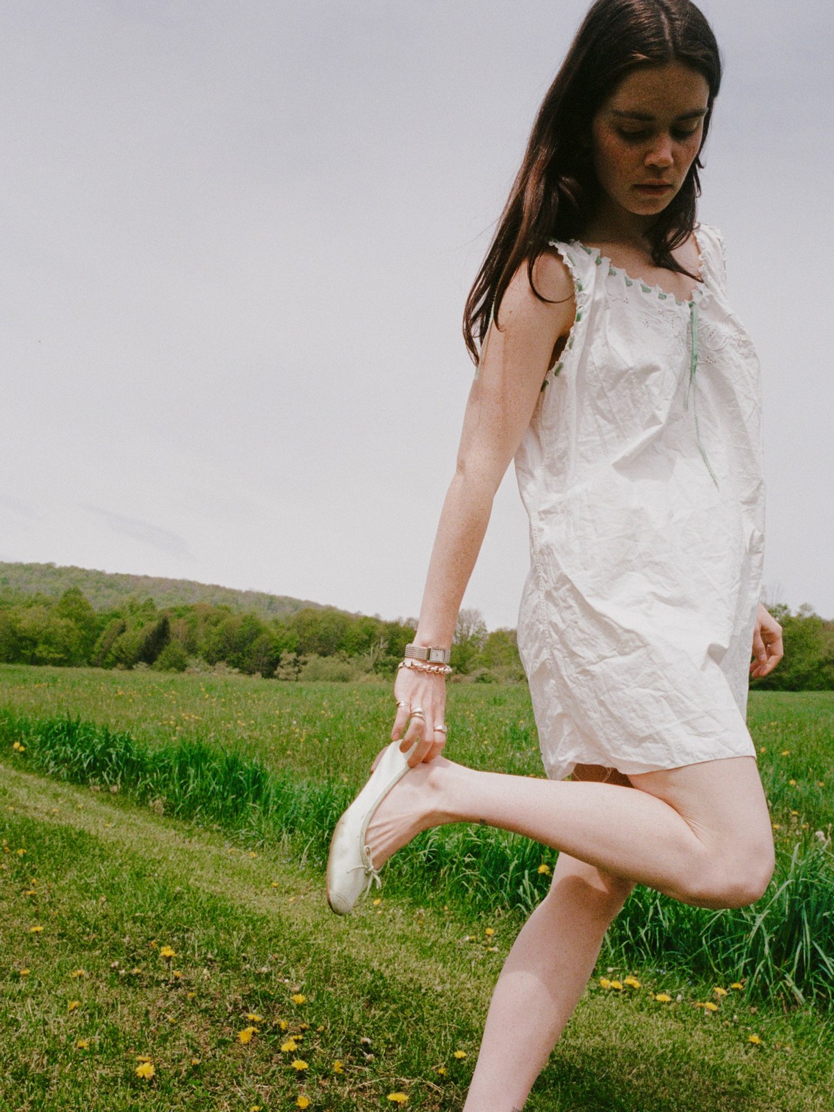 Woman in a white dress outdoors with a watch and bracelet