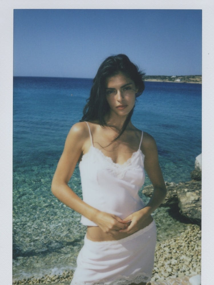 Model in a pink lace-trim set beside the Mediterranean