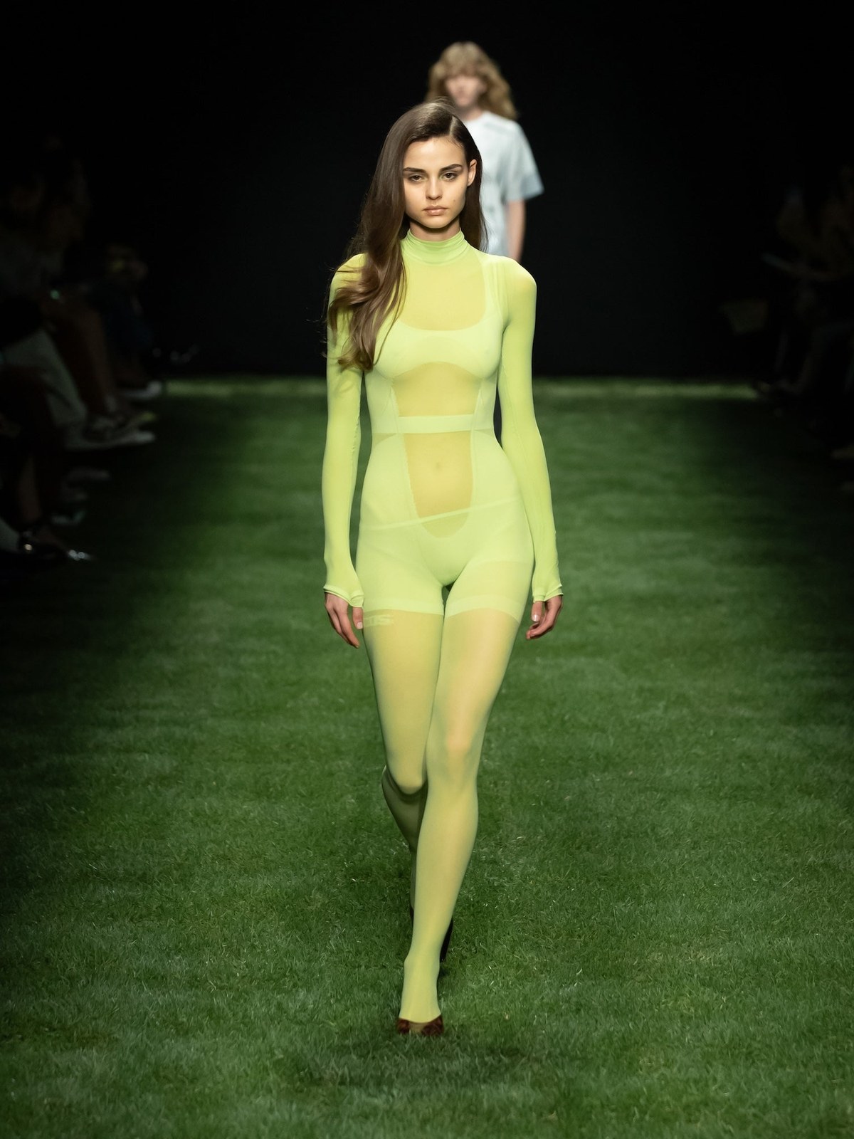 GCDS Spring Summer 2025 runway model in a translucent lime look on a grass runway