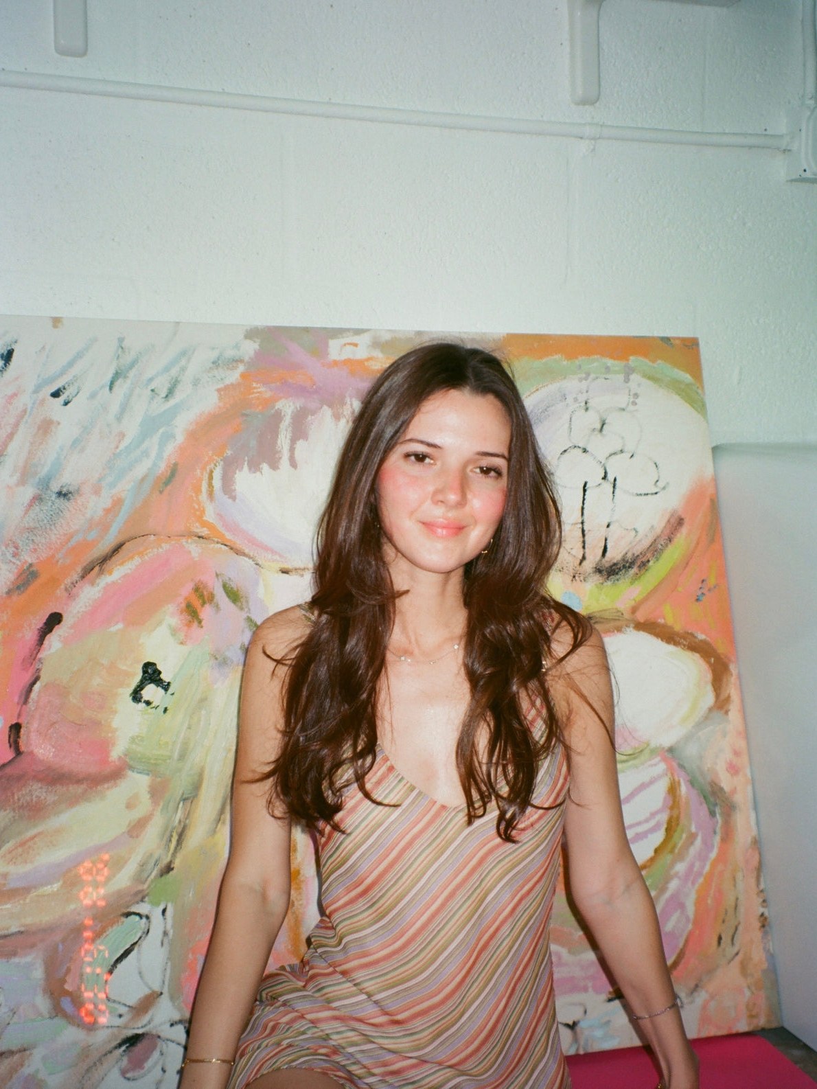Model in a striped top in a bright room with an abstract painting