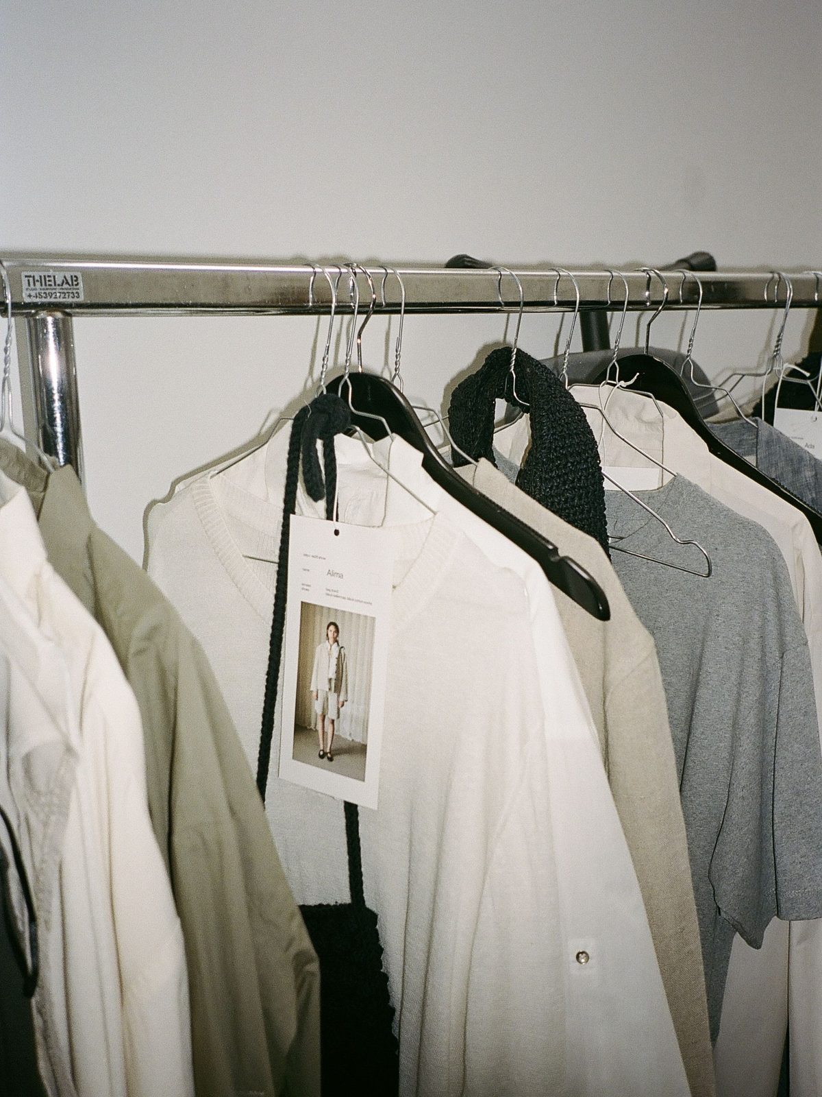 White and grey shirts hanging close together on a rail